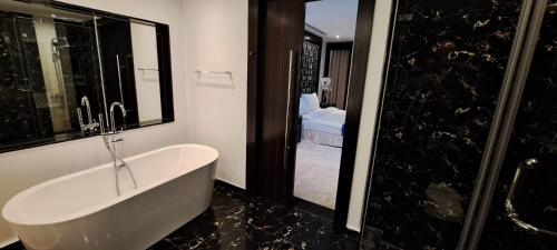a bathroom with a bath tub and a shower at Skyline Apartments in Manama