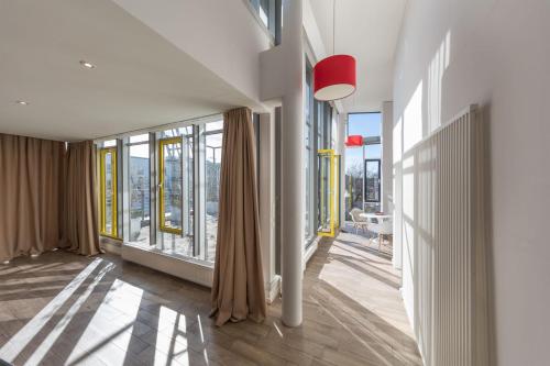 a living room with large windows and a floor to ceiling at Brera Serviced Apartments Munich West in Munich