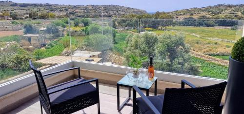 a balcony with a table with a bottle of wine at Valley View in Qrendi