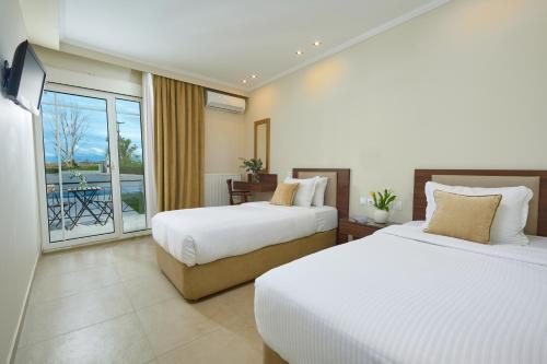 een hotelkamer met 2 bedden en een balkon bij Filippos Hotel in Halkidona