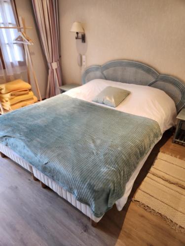 a bedroom with a bed with a blue blanket on it at Résidence Normandie in Conches-en-Ouche