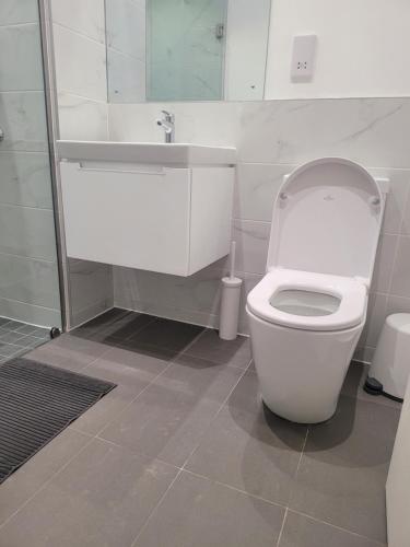 a bathroom with a white toilet and a sink at RT PROPERTIES @ THE LENNOX AIRPORT RESIDENTIAL in Accra