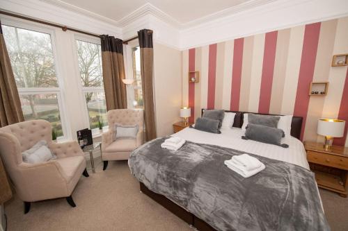 1 dormitorio con 1 cama grande, silla y ventana en Mont Millais, en Bridlington