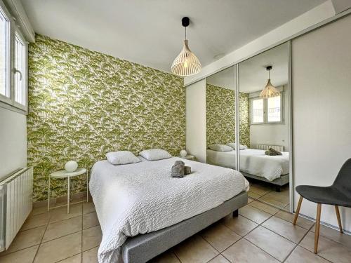 Schlafzimmer mit einem Bett und einem Spiegel in der Unterkunft Appart T3 LE PATIO - avec terrasse in Boujan-sur-Libron