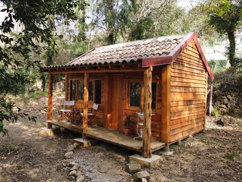 a small wooden cabin in the middle of a forest at Associação Quinta das Relvas in Branca