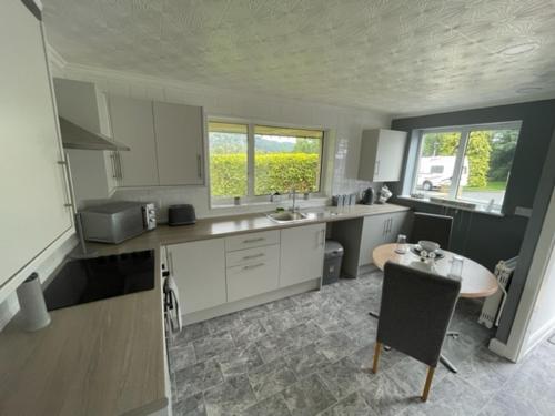 a kitchen with a sink and a table in it at Parklands Bungalow in Nelson