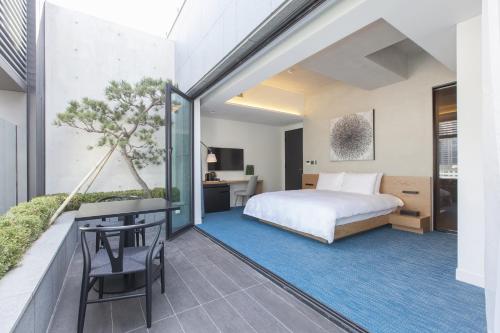 1 dormitorio con 1 cama, mesa y sillas en StayB Hotel Myeongdong, en Seúl