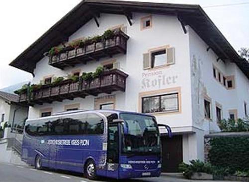 a blue bus parked in front of a building at Pension Kofler in Vollan