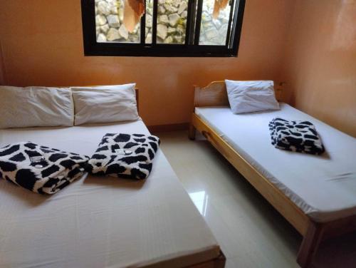 dos camas sentadas una al lado de la otra en una habitación en AJjaa's Place, en Sagada