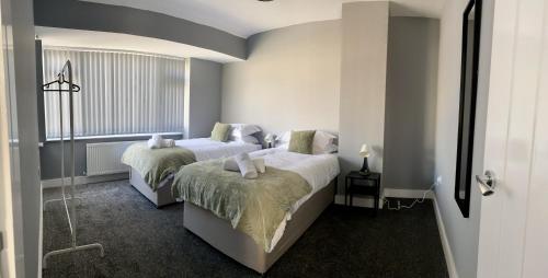 a bedroom with two beds and a window at Gateway Getaway in Horsforth Sleeps 7 in Leeds