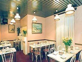 a dining room with white tables and chairs at Avenir Hotel in Paris