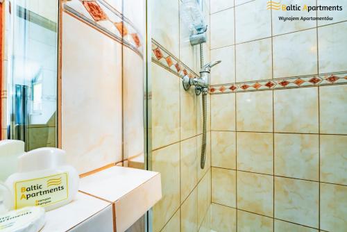 a bathroom with a shower with a glass door at Baltic Apartments - Willa Dorota in Świnoujście