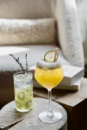 a drink on a wooden table next to a book at Novotel Megève Mont-Blanc in Megève