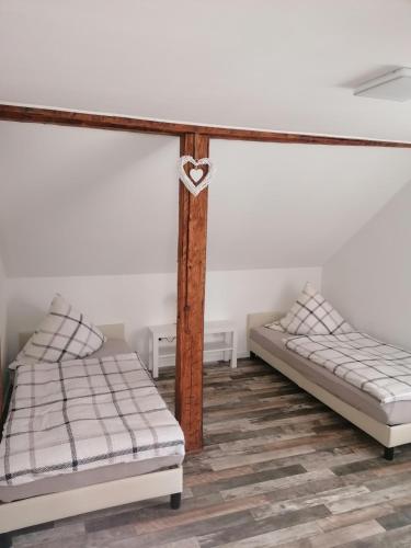two beds sitting in a room with at Ferienwohnung IV Sarrebriese in Bottmersdorf