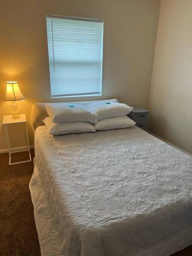 een slaapkamer met een wit bed en een raam bij Minimalist Mansion in Shiloh