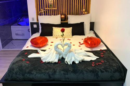a bed with two swans made out of flowers at Suite romantique Spa Balnéothérapie in Échirolles