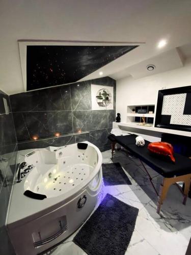 a bathroom with a large white tub in a room at Suite romantique Spa Balnéothérapie in Échirolles