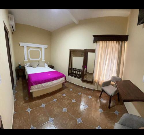 sypialnia z łóżkiem, stołem i krzesłem w obiekcie Hotel Victorina de Híjar w mieście Tequila