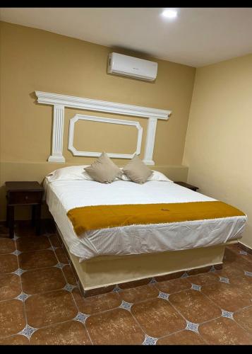 a bedroom with a large bed with a white headboard at Hotel Victorina de Híjar in Tequila