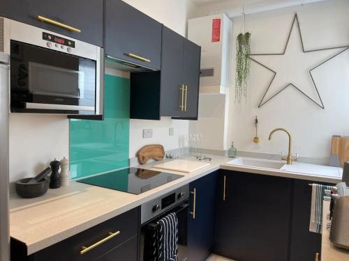 una cocina con armarios azules y una estrella en la pared en Top Deck - Fresh, stylish seaside apartment, en Ventnor