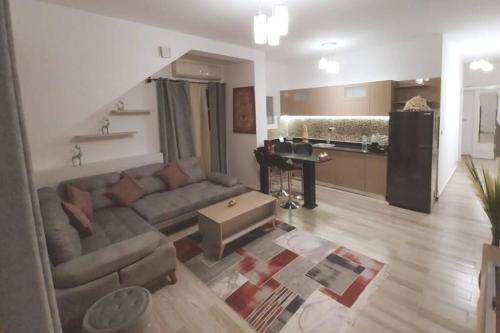 een woonkamer met een bank en een keuken bij Luxury Getaway /Brand New 2BR /Wi-Fi /Full Kitchen in Sharm El Sheikh