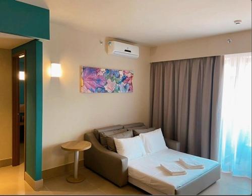 a living room with a couch and a bed at Apartamento Resort Solar das Águas em Olímpia in Olímpia