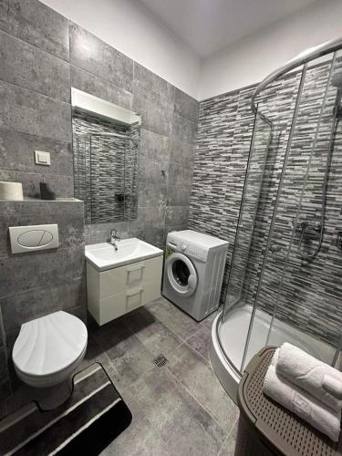een badkamer met een wastafel en een douche bij Divine Comfort Apartments Palas Mall in Iaşi