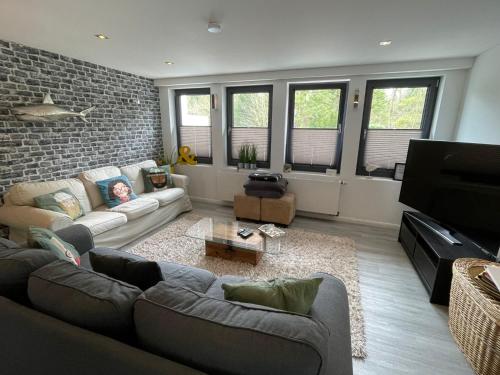 a living room with a couch and a brick wall at BUDE 17 in Timmendorfer Strand