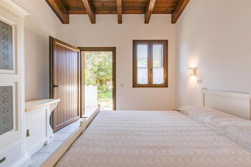 ein Schlafzimmer mit einem großen Bett und einem Fenster in der Unterkunft Agriturismo Casa Marmida in Pardu Atzei