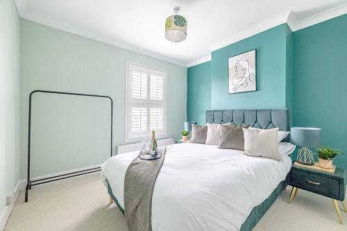 sypialnia z niebieskimi ścianami i dużym łóżkiem w obiekcie Victorian Cottage, Close 2 All The Sights, Parking w mieście Windsor