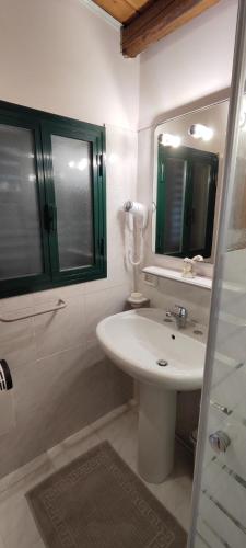 a white bathroom with a sink and a mirror at Voscenza Benerica in Vittoria