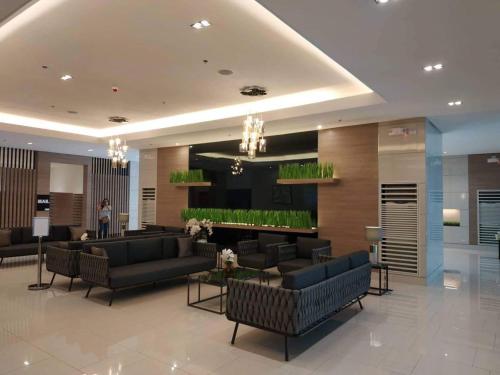 a lobby with couches and a fireplace in a hotel at Grass Residences by Team A in Manila