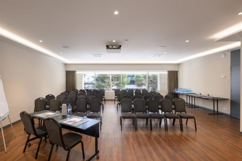 a conference room with chairs and tables and a large window at Melia Lisboa Oriente Hotel in Lisbon