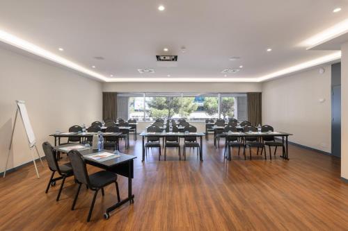 a large room with tables and chairs in a classroom at Melia Lisboa Oriente Hotel in Lisbon