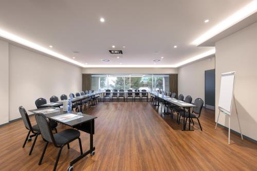 a conference room with tables and chairs and a whiteboard at Melia Lisboa Oriente Hotel in Lisbon