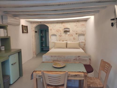 um quarto com uma cama, uma mesa e cadeiras em Apanemo Beach House Agios Nikolaos Kimolos em Kimolos