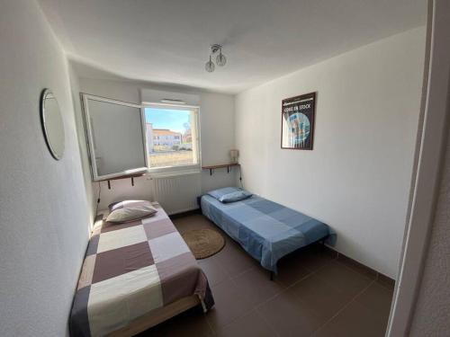 une chambre avec deux lits et une fenêtre dans l'établissement Cosy T3 gare Terrasse + parking, à Sète