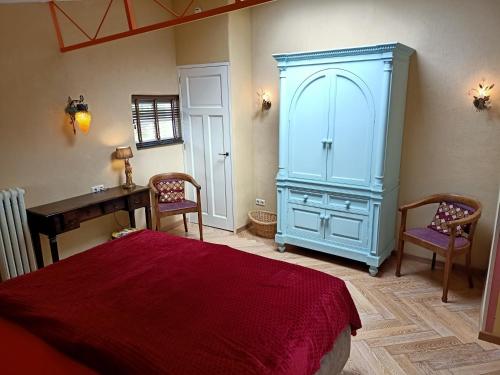 a bedroom with a large blue cabinet and two chairs at De Ketse Steenuil in Kaatsheuvel