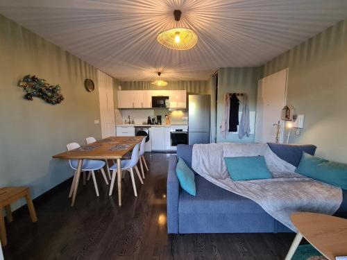 ein Wohnzimmer mit einem blauen Sofa und einem Tisch in der Unterkunft Stella in Arès