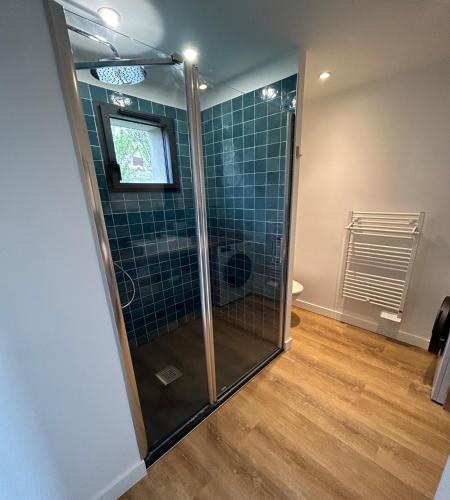 La salle de bains est pourvue d'une douche et de carrelage bleu. dans l'établissement Kerguido, à l'Île-aux-Moines