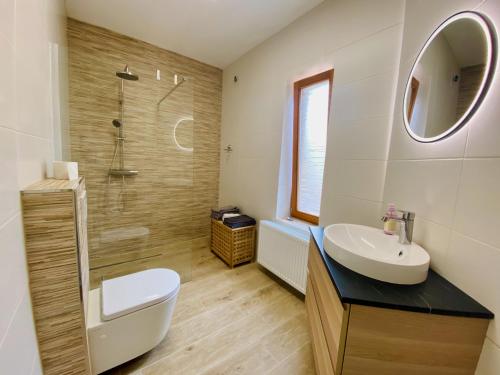 a bathroom with a sink and a toilet and a shower at Ferienwohnung Reuscher, Trier-Newel in Newel
