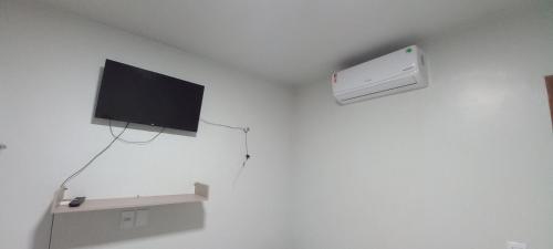 a room with a tv on a white wall at A.N Hotel in Boa Vista
