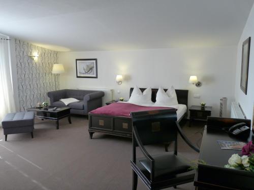 a hotel room with a bed and a couch at Spreewaldhof Romantik - Hotel Garni in Neu Zauche