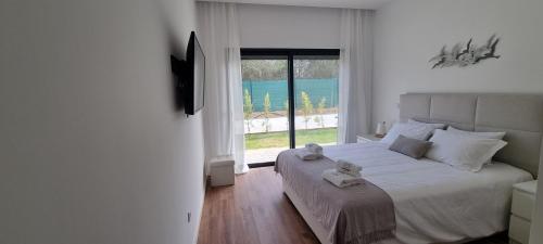 a bedroom with a large bed and a large window at Valverde 2 Villa, Vilamoura, Algarve, only 5 minutes from Marina, Golf and Beach in Vilamoura