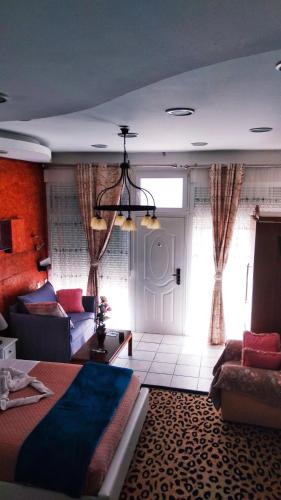 a bedroom with a bed and a couch and a window at Sweet Home Suite in Korinthos