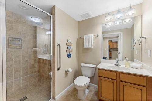 La salle de bains est pourvue de toilettes, d'une douche et d'un lavabo. dans l'établissement 5 Star Resort 2BR 2 BATH King Suite Shuttle Pools Across from Beach, à Destin