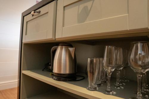 a cupboard with wine glasses and a tea kettle at Cabana Serra Grande Sossego in Gramado