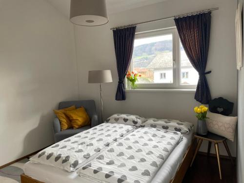 una camera con un grande letto e una finestra di "Ferienhaus am Mondsee" mit direktem Schafbergblick im Salzkammergut bei Salzburg a Mondsee