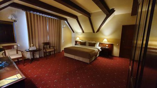 une chambre d'hôtel avec un lit, une table et des chaises dans l'établissement Hotel Garden Club, à Braşov