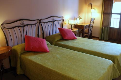 a hotel room with two beds with red pillows at Las Fontaninas in Noceda del Bierzo